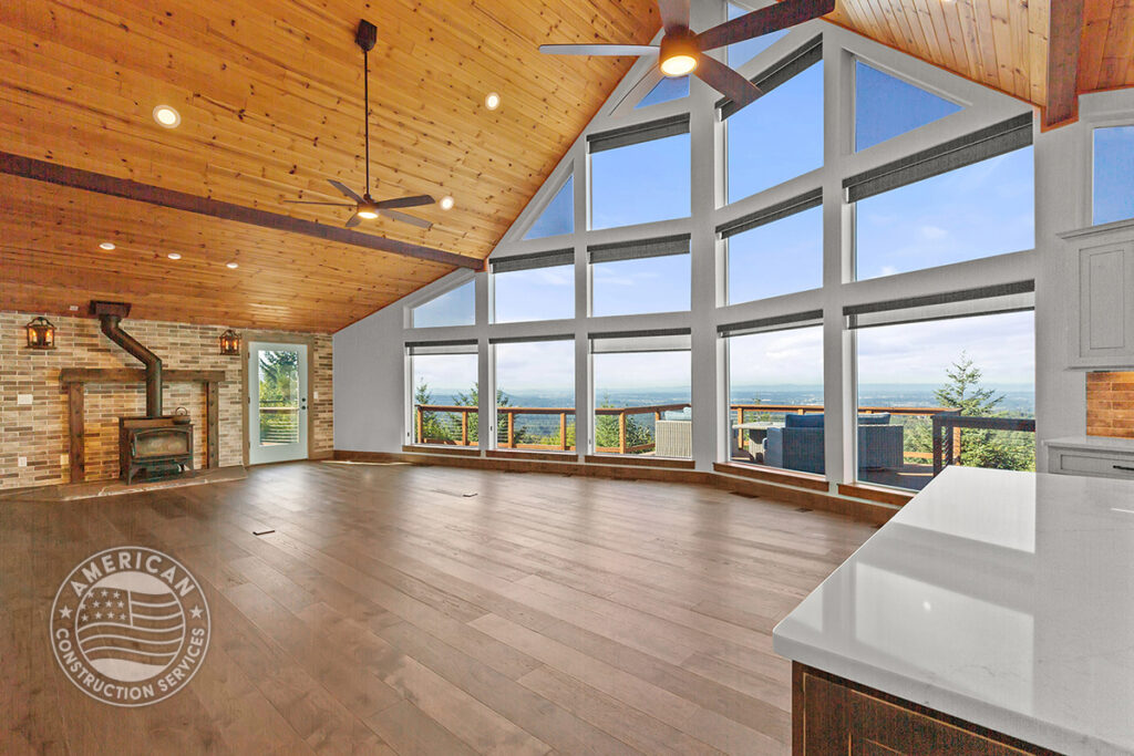 Great room remodel with vaulted, wood beam ceilings, and wall of windows by American Construction Services, Corp.