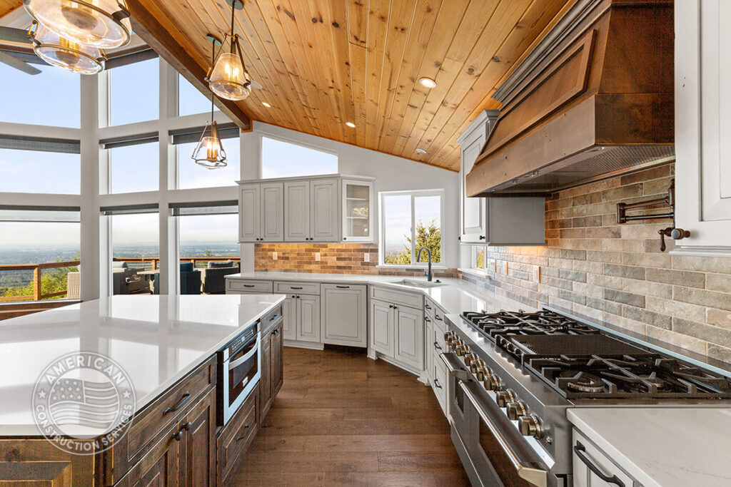 Kitchen remodel with island, white cabinets, vaulted wood beam ceilings by American Construction Services, Corp.