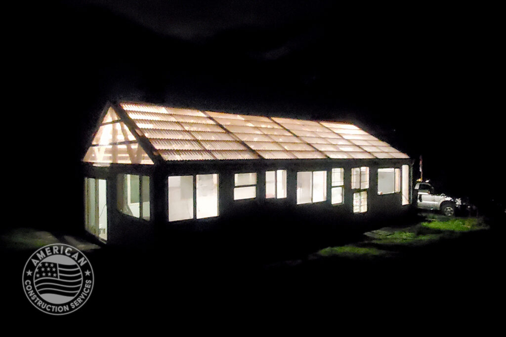 Nighttime exterior of newly constructed greenhouse built using 50% repurposed building material. Built by American Construction Services, Corp. in Southwest Washington