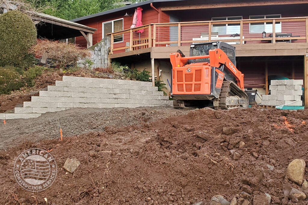 American Construction Services Corp Site prep for a swim spa. Includes dirt work, retaining wall, underground electrical, heavy pad with rebar.